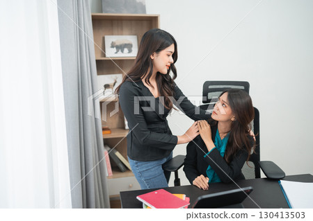 Two Professional Women Engaging in a Collaborative Workspace Conversation Two Professional Women Engaging in a Collaborative Workspace Conversation 130413503