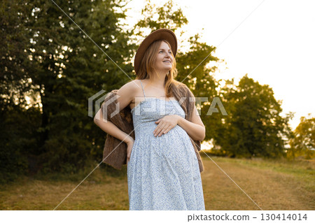 Pregnant woman in summer dress enjoying nature outdoors 130414014