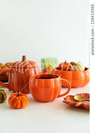 Autumnal tea set with pumpkin decor and cake on a white table. Autumnal tea set with pumpkin decor and cake on a white table. 130414568