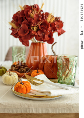 Thanksgiving table setting with decorative pumpkins, candles and string lights on white wooden table Thanksgiving table setting with decorative pumpkins, candles and string lights on white wooden table 130414584