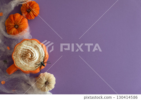 Halloween themed flat lay with a pumpkin latte, decorative pumpkins and spiderwebs on a purple background. Halloween themed flat lay with a pumpkin latte, decorative pumpkins and spiderwebs on a purple background. 130414586