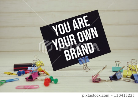 You Are Your Own Brand text on paper card with stationary on wooden background 130415225