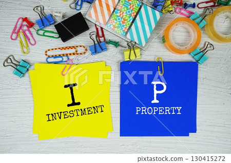 IP - Investment Property text on stick note with stationery on concrete background 130415272
