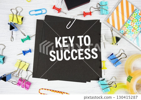 Key To Success text on stick note with stationery on concrete background 130415287