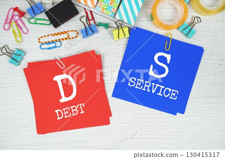 DS - Debt Service text on stick note with stationery on concrete background DS - Debt Service text on stick note with stationery on concrete background 130415317