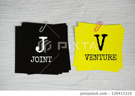 JV - Joint Venture text on stick note on concrete background 130415328