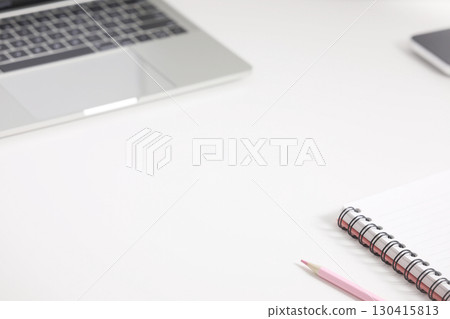 spiral notebook and pink color pencil and keypad laptop on a white desk surface spiral notebook and pink color pencil and keypad laptop on a white desk surface 130415813