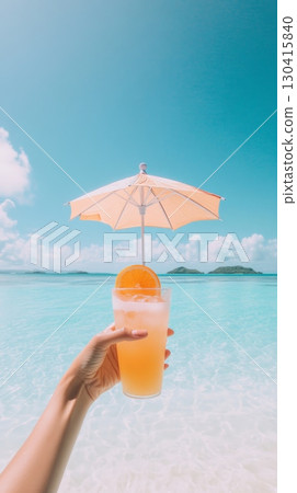 Hand holding refreshing cocktail decorated with orange slice and cocktail umbrella on beautiful tropical beach with turquoise water and islands in the distance, enjoying summer vacation 130415840