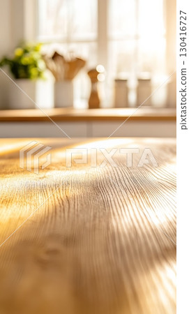 Sunlight illuminating an empty wooden table in a blurred kitchen background, creating a warm and inviting atmosphere, perfect for displaying products or showcasing culinary creations 130416727