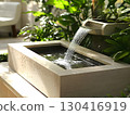 Minimalist garden water fountain with water flowing to the round water pond	 130416919