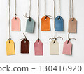 Paper product tags in various colors on white background with jute yarns tied to the holes.	 130416920