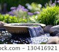 Minimalist garden water fountain with water flowing from the fountain bowl	 130416921