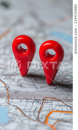 Two vibrant red location pins marking precise points on a detailed physical map, highlighting key areas for navigation and travel planning, enhancing the journey experience 130416960