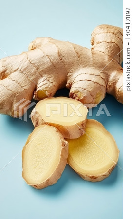Fresh ginger root and slices arranged on a light blue background, emphasizing health benefits and culinary uses of this versatile spice for a healthy lifestyle 130417092
