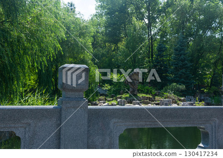 chinese garden with pond and stone bridge in the morning. Summer landscape 130417234