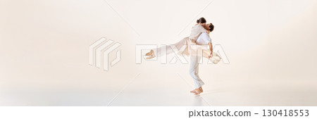 Ballet dancers embrace in airborne pose with flowing fabric, capturing graceful lines, and suspended motion. Banner Ballet dancers embrace in airborne pose with flowing fabric, capturing graceful lines, and suspended motion. Banner 130418553