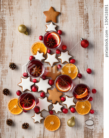 Christmas tree made of gingerbread cookies, mulled wine, cranberries, and dried oranges on wooden background. Creative festive flat lay.tree composition with mulled wine, cookies, oranges and Christmas tree made of gingerbread cookies, mulled wine, cranberries, and dried oranges on wooden background. Creative festive flat lay.tree composition with mulled wine, cookies, oranges and 130418891