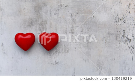 Two red wooden hearts are lying on grey textured background representing love and affection on valentine's day, creating a romantic and minimalist composition with copy space 130419219