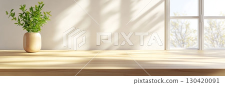 Sunlight illuminates an empty wooden kitchen countertop with a small potted plant, creating a bright and inviting space perfect for cooking or dining, with a window view of trees in the background 130420091