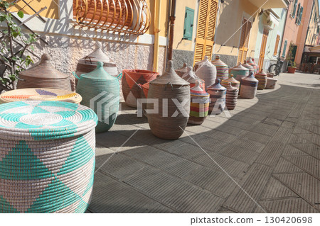 Traditional woven African baskets on street of old town in Italy. Private business, market and sales. Objects for kitchen, home, handmade. 130420698