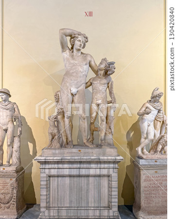 VATICAN CITY, ROME, ITALY - AUGUST 02, 2025 Statue of drunk Dionysus leaning on Satyr as holds a cup of wine in his hand. Ancient god of fertility hangs out with his woodland companion 130420840