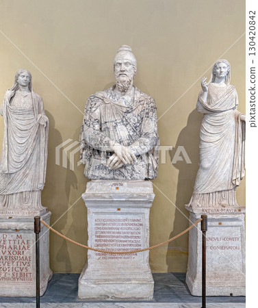 VATICAN CITY, ROME, ITALY - AUGUST 02, 2025 Classical marble sculpture of a bearded Dacian man wearing typical pointed Phrygian cap, flanked by two statues of robed women VATICAN CITY, ROME, ITALY - AUGUST 02, 2025 Classical marble sculpture of a bearded Dacian man wearing typical pointed Phrygian cap, flanked by two statues of robed women 130420842