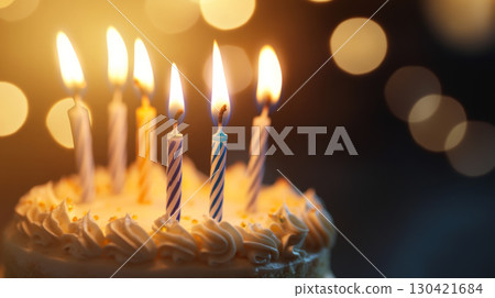Close-Up of Lit Birthday Candles on Frosted Cake 130421684