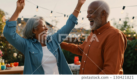 Elderly couple revels in pure joy under twinkling lights, capturing life's happiest moments Elderly couple revels in pure joy under twinkling lights, capturing life's happiest moments 130421821