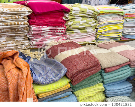 Colorful stacks of towels in various patterns and shades arranged in a shop. Lifestyle, leisure and consumer choice expressed through textile, comfort and everyday household essentials Colorful stacks of towels in various patterns and shades arranged in a shop. Lifestyle, leisure and consumer choice expressed through textile, comfort and everyday household essentials 130421881