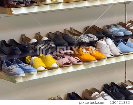 Shelves of shoes in multiple styles, colors and designs displayed in a store. Fashion, consumer choice and retail commerce as a symbol of individuality, lifestyle and modern trends. 130421883