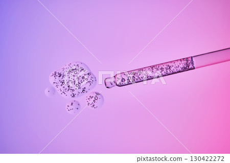 Transparent pipette with a serum texture with bubbles on a purple background. 130422272