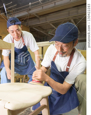 老兵教年輕人製作家具的合作場景。 老兵教年輕人製作家具的合作場景。 130422283
