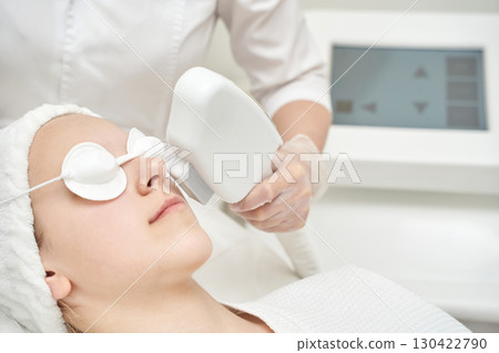 Female receiving laser skin treatment in spa clinic for facial rejuvenation 130422790