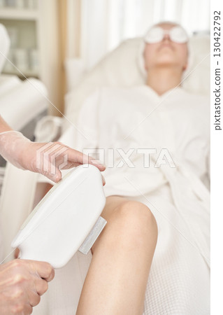 Female adult receiving laser hair removal treatment at spa clinic for smooth 130422792