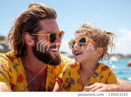 Happy father and son enjoy sunny day wearing matching sunglasses and shirts 130423242