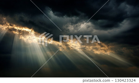 Sun rays piercing through dark dramatic clouds in a powerful natural scene 130423324