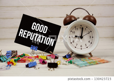 Good Reputation text on paper card with alarm clock and stationary on wooden background Good Reputation text on paper card with alarm clock and stationary on wooden background 130423723