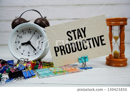 Stay Productive text on paper card with alarm clock and stationary on wooden background 130423850