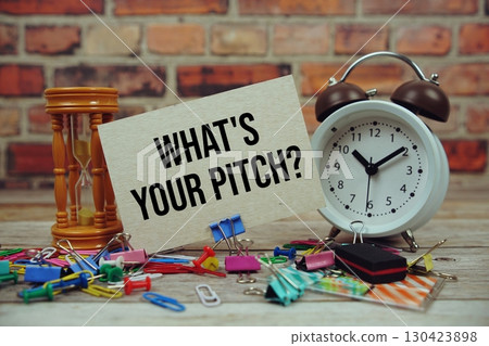 What's Your Pitch? text on paper card with alarm clock and stationary on wooden background 130423898