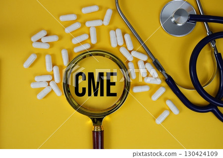CME abbreviation of Continuing Medical Education text with Stethoscope and magnifying glass flat lay on yellow background 130424109