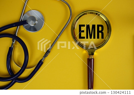 EMR abbreviation of Electronic Medical Records text with Stethoscope and magnifying glass flat lay on yellow background EMR abbreviation of Electronic Medical Records text with Stethoscope and magnifying glass flat lay on yellow background 130424111
