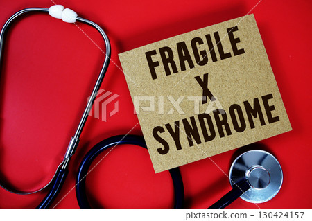 Fragile X Syndrome text written on paper card with stethoscope on red background 130424157