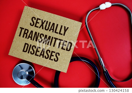 Sexually Transmitted Diseases; text written on paper card with stethoscope on red background 130424158