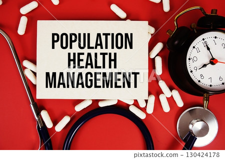 Population Health Management text written on paper card with stethoscope, alarm clock and medicine capsule on red background 130424178