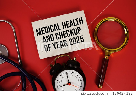 Medical Health and Checkup of Year 2025 text written on paper card with stethoscope, alarm clock and magnifying glass red background 130424182