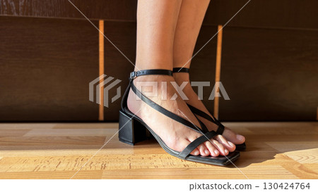 Close Up of Woman Trying on Stylish Sandals Female Legs, Footwear Fashion and Shopping Concept 130424764