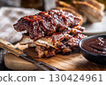 Pork BBQ glazed ribs and sauce on wooden cutting board. 130424961