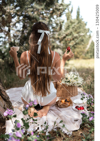 Picnic Woman Strawberries: Sunny day, woman enjoys picnic with strawberries and coffee in a serene meadow. Picnic Woman Strawberries: Sunny day, woman enjoys picnic with strawberries and coffee in a serene meadow. 130425009