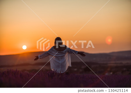 Lavender Sunset Woman: Girl enjoys sunrise in lavender field at dusk for peace. Lavender Sunset Woman: Girl enjoys sunrise in lavender field at dusk for peace. 130425114