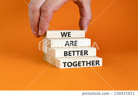 We are better together symbol. Concept words phrase We are better together on beautiful wooden blocks. Beautiful orange background. Businessman hand. Business We are better together concept Copy space 130425851